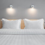 One,Double,Bed,In,A,Hotel,Near,Flowers,On,The