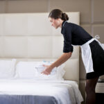Maid,Making,Bed,In,Hotel,Room